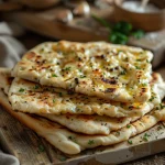 Close-up of golden-brown cottage cheese flatbreads on a rustic wooden surface.