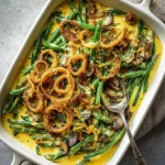 Close-up of a Green Bean Casserole topped with crispy fried onions in a white dish.
