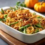 Close-up of a creamy green bean casserole topped with crispy fried onions.
