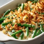 Close-up of a baked Southern green bean casserole topped with crispy fried onions.