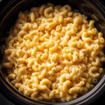 Close-up of creamy Crockpot Mac and Cheese with bubbly cheese on top.