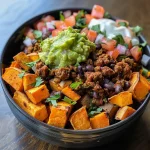 Close-up of a colorful Sweet Potato Taco Bowl filled with ingredients.