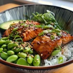 A close-up side view of a Teriyaki Salmon Sushi Bowl filled with rice, salmon, avocado, and garnishes.