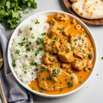 A close-up view of a creamy Instant Pot Butter Chicken dish with tender chicken pieces and a sprinkle of fresh cilantro.