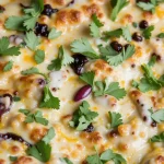 Close-up of a high protein chicken burrito casserole topped with cheese and garnished with cilantro.