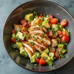 Close-up view of Healthy Avocado Chicken Salad with colorful ingredients and textures.