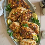 Close-up of a yogurt marinated chicken cutlet with golden-brown sear, garnished with fresh parsley.