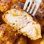 Close-up of a succulent Instant Pot chicken breast, glistening with seasoning and set against a cozy background.