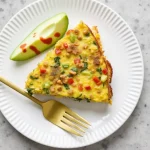 Close-up of a colorful vegan vegetable frittata with vibrant spinach, bell peppers, and tomatoes.