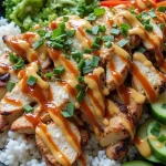 Close-up of a vibrant Bang Bang Chicken Bowl featuring chicken, rice, and colorful vegetables.