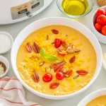 Close-up of creamy Crockpot Crab Dip in a bowl, garnished and ready to serve.