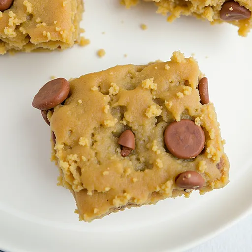 A slice of moist banana bars with a blurred cozy background, highlighting their appeal.