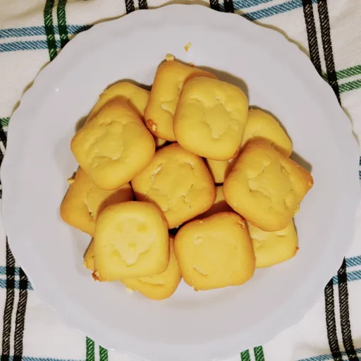 Three ingredient butter cookies arranged beautifully, with a blurred kitchen background enhancing their appeal.