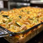 Close-up side view of a rotisserie chicken and zucchini casserole with a golden brown topping.