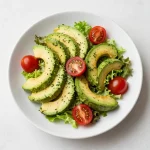 A vibrant avocado salad with cherry tomatoes, cucumber, and a sprinkle of feta cheese