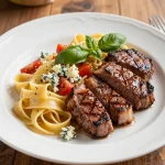 A delicious plate of steakhouse pasta topped with grilled steak and herbs