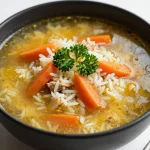 A bowl of slow cooker chicken and rice soup garnished with fresh parsley