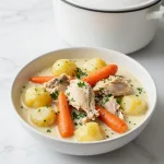 A bowl of Garlic Parmesan Chicken Stew garnished with fresh parsley