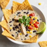 A bowl of Chicken Quesadilla Soup topped with cheese and cilantro