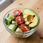 A vibrant cucumber and tomato salad with fresh herbs and a drizzle of dressing