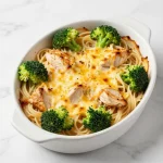 A plate of easy chicken and broccoli pasta garnished with parmesan cheese