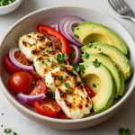 A vibrant avocado and halloumi salad on a rustic wooden table